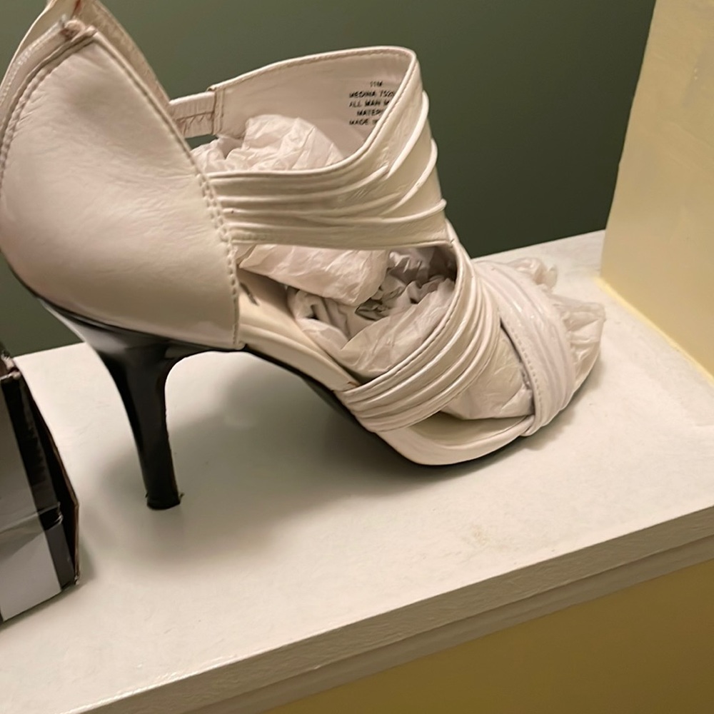 White shoe with black heel, zip in the back.